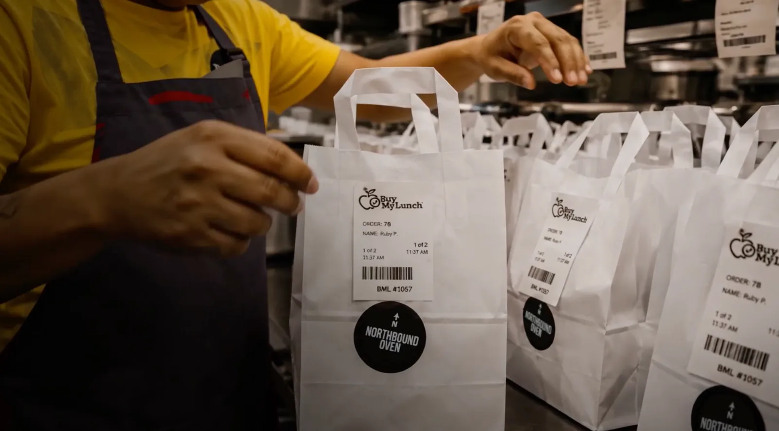 Restaurant lunch bags labeled and organized for school delivery.